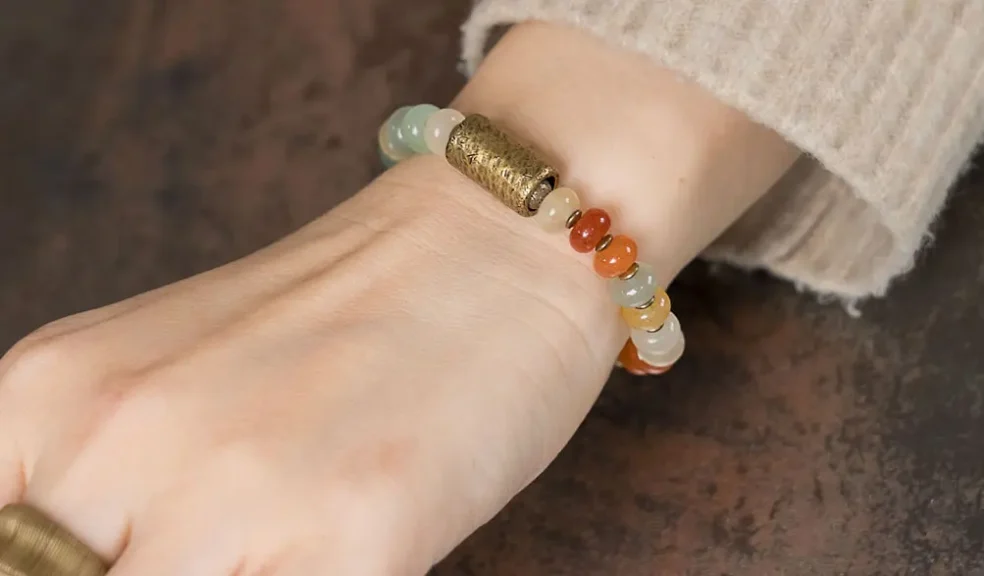 7 Chakra Bracelet Meaning & Benefits: A Guide to Spiritual Balance 2 - Buddha Bodhis A wrist with a 7 Chakra bracelet stacked with other crystal bracelets, showing a popular wearing style.