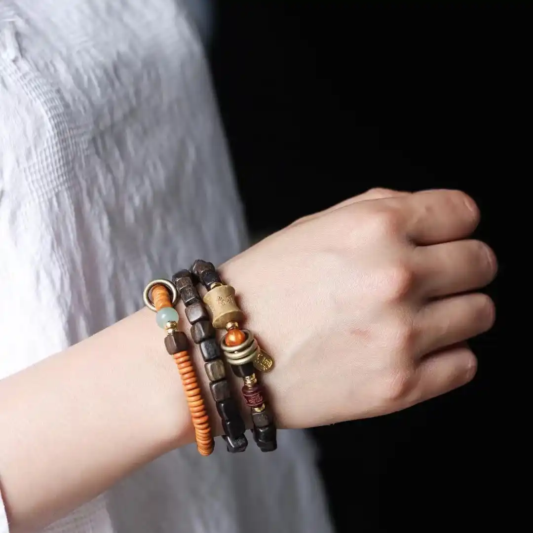 Tibetan Dzi Bead Mala | Ebony Wood Tassel Bracelet 1 - Buddha Bodhis Stacking Tibetan copper and red string bracelets on wrist