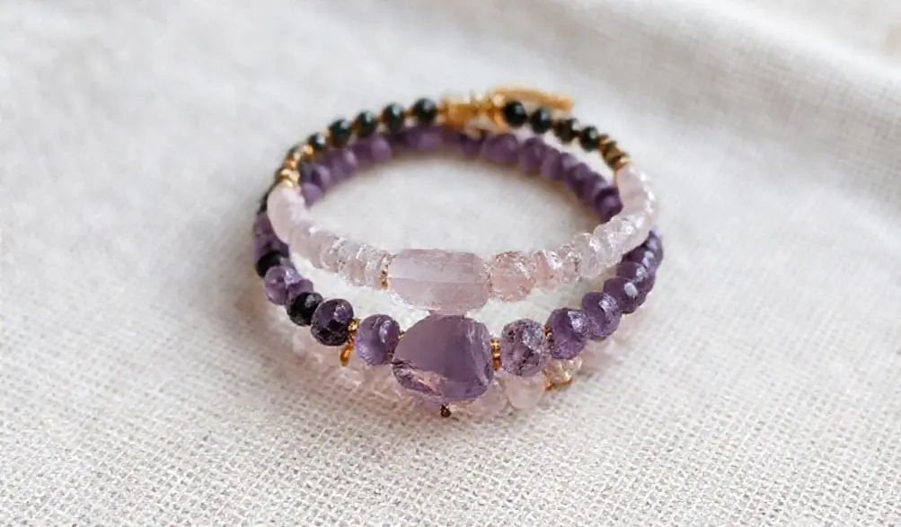 Amethyst Bracelet Meaning: Your Complete Guide to Peace, Intuition, and Spiritual Healing 3 - Buddha Bodhis A stack of crystal bracelets including Amethyst, Rose Quartz, and Black Tourmaline, showing powerful combinations.